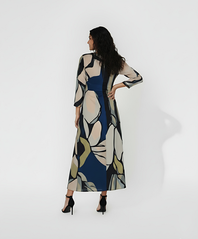 Ankle-length dress with a high, closed back and long fitted sleeves that emphasize a streamlined silhouette. The continuous abstract pattern flows across the entire back of the garment.