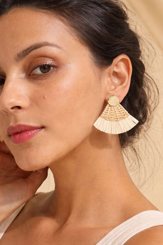 Gold fan-shaped straw earrings with a woven raffia texture and a small gold stud, perfect for a bohemian summer look.