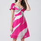 Smiling model in short abstract chinon dress with twisted neckline and playful puff sleeves.