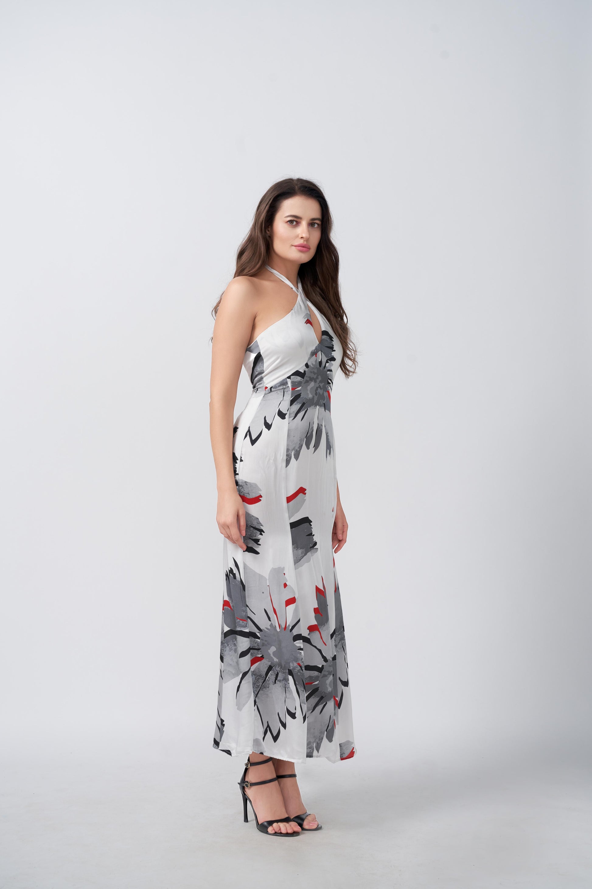 Full frontal pose of model in ankle-length floral satin dress with tie-back halter neckline.