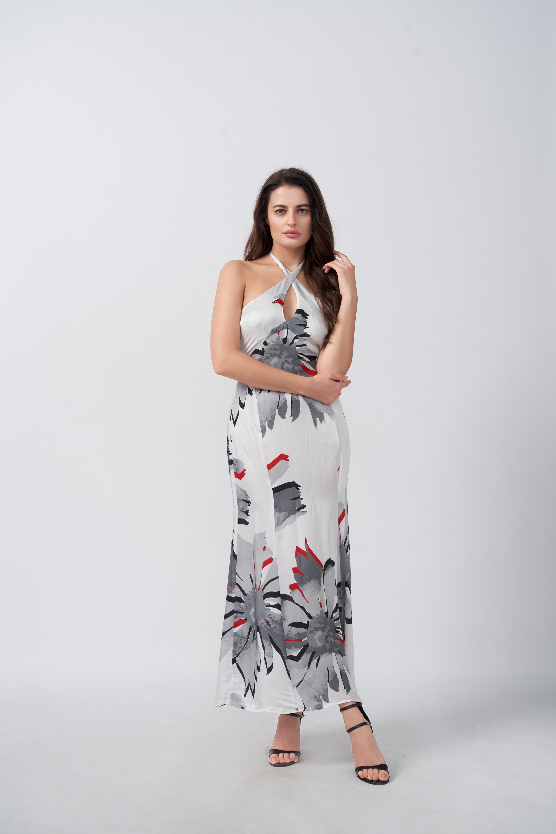 Model in halter neck satin dress walking with a side angle, showcasing soft fabric movement.