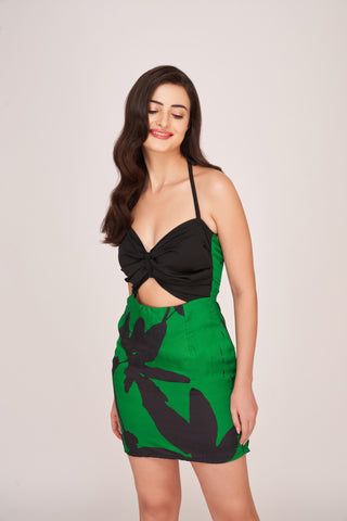 Sweetheart bodice featuring a central twisted knot detail and a stylish midriff cutout. The solid black top contrasts sharply with the vibrant skirt.