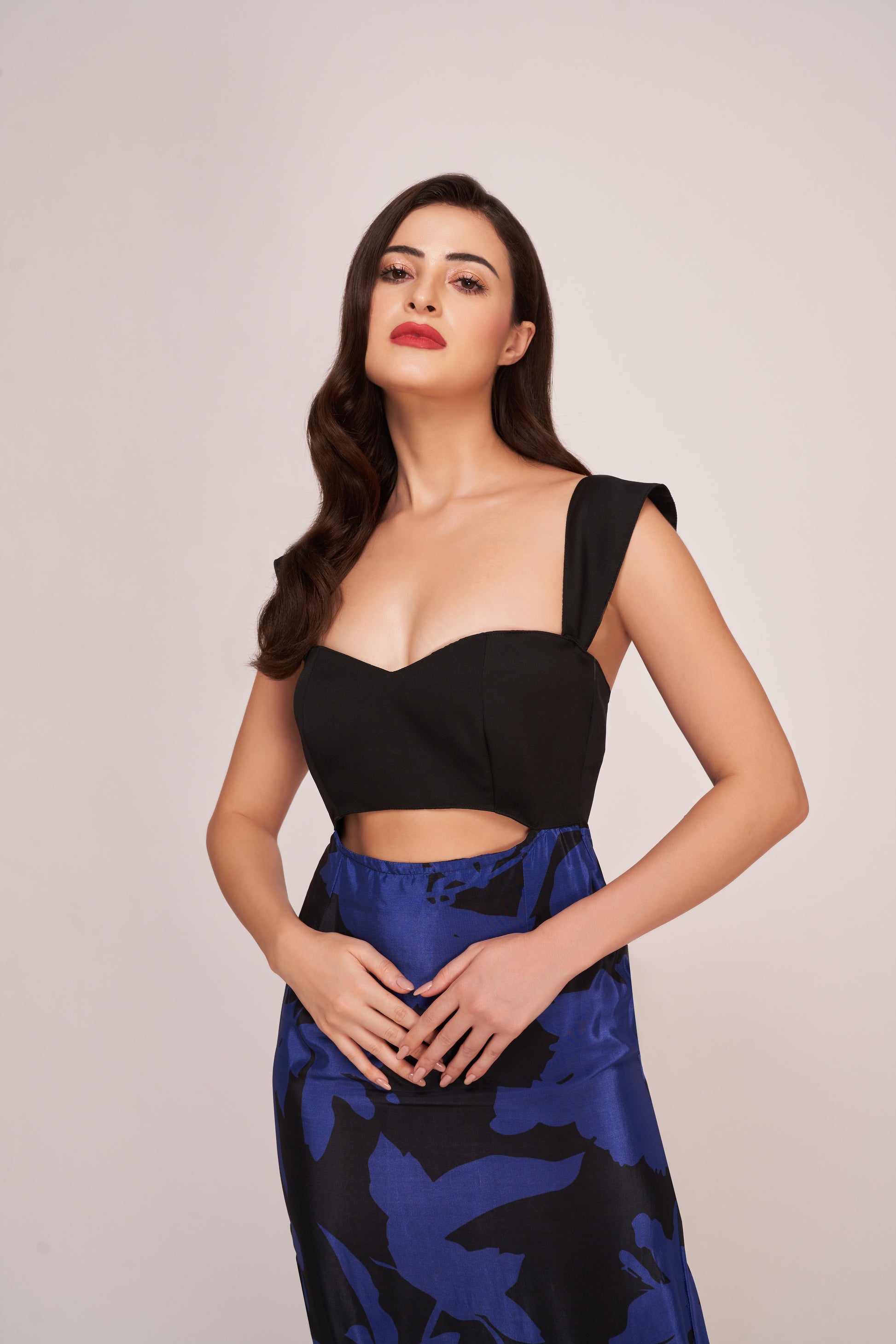 Close-up of model in long floral crepe dress with bold sweetheart neckline and fitted waist cut-out.