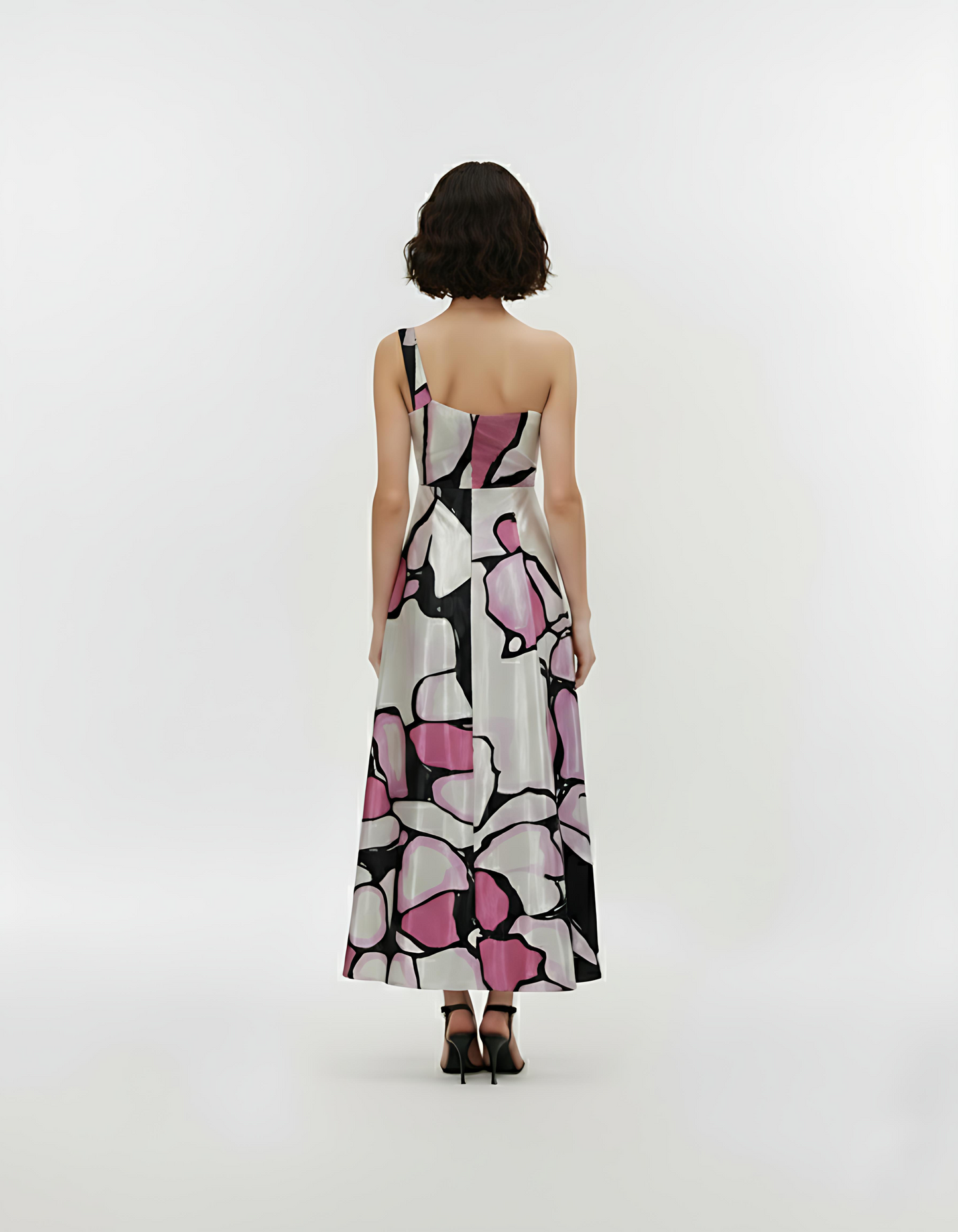 Back view of a one-shoulder crepe maxi dress featuring an asymmetric neckline, fitted waistband, and a flowy A-line silhouette.