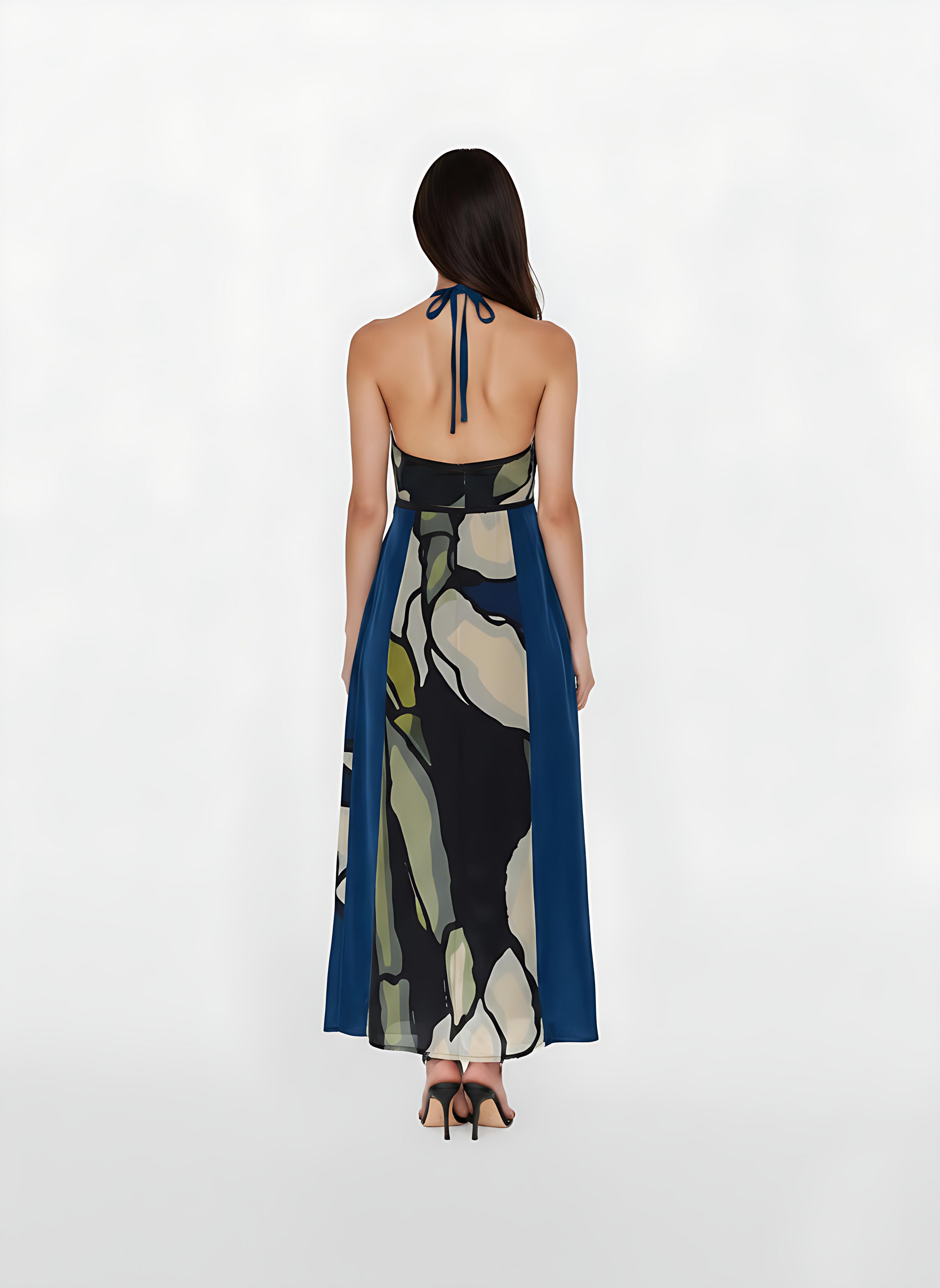 Backless maxi gown with a delicate halter tie that emphasizes a dramatic open-back design. The smooth, airy fabric is patterned with large-scale botanical shapes offering a breezy yet elegant feel for high-end resort wear. . 