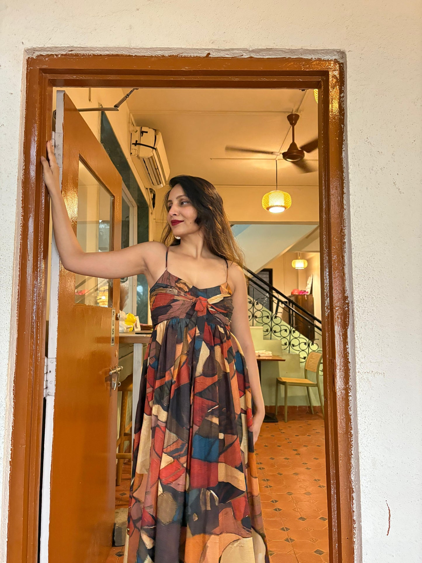 Multi-colored abstract geometric print in warm earth tones of rust, ochre, and deep teal, accented by bold shapes throughout the fabric.