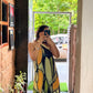 Elegant halter-neck maxi dress featuring a criss-cross neckline and a relaxed, flowy fit that highlights the intricate olive and ochre abstract design.