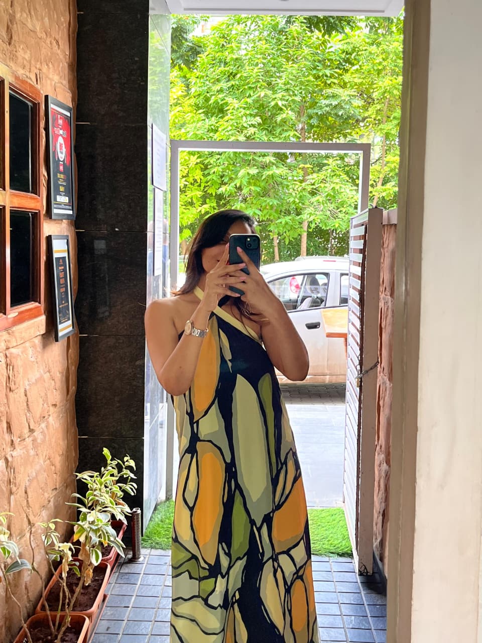 Elegant halter-neck maxi dress featuring a criss-cross neckline and a relaxed, flowy fit that highlights the intricate olive and ochre abstract design.
