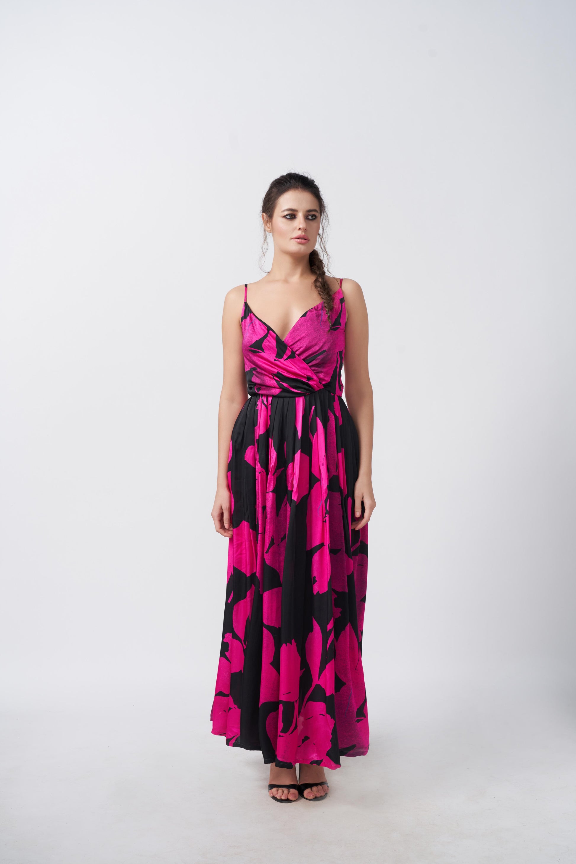 Full-length view of model in pink and black floral gathered flare dress with a flowing silhouette.