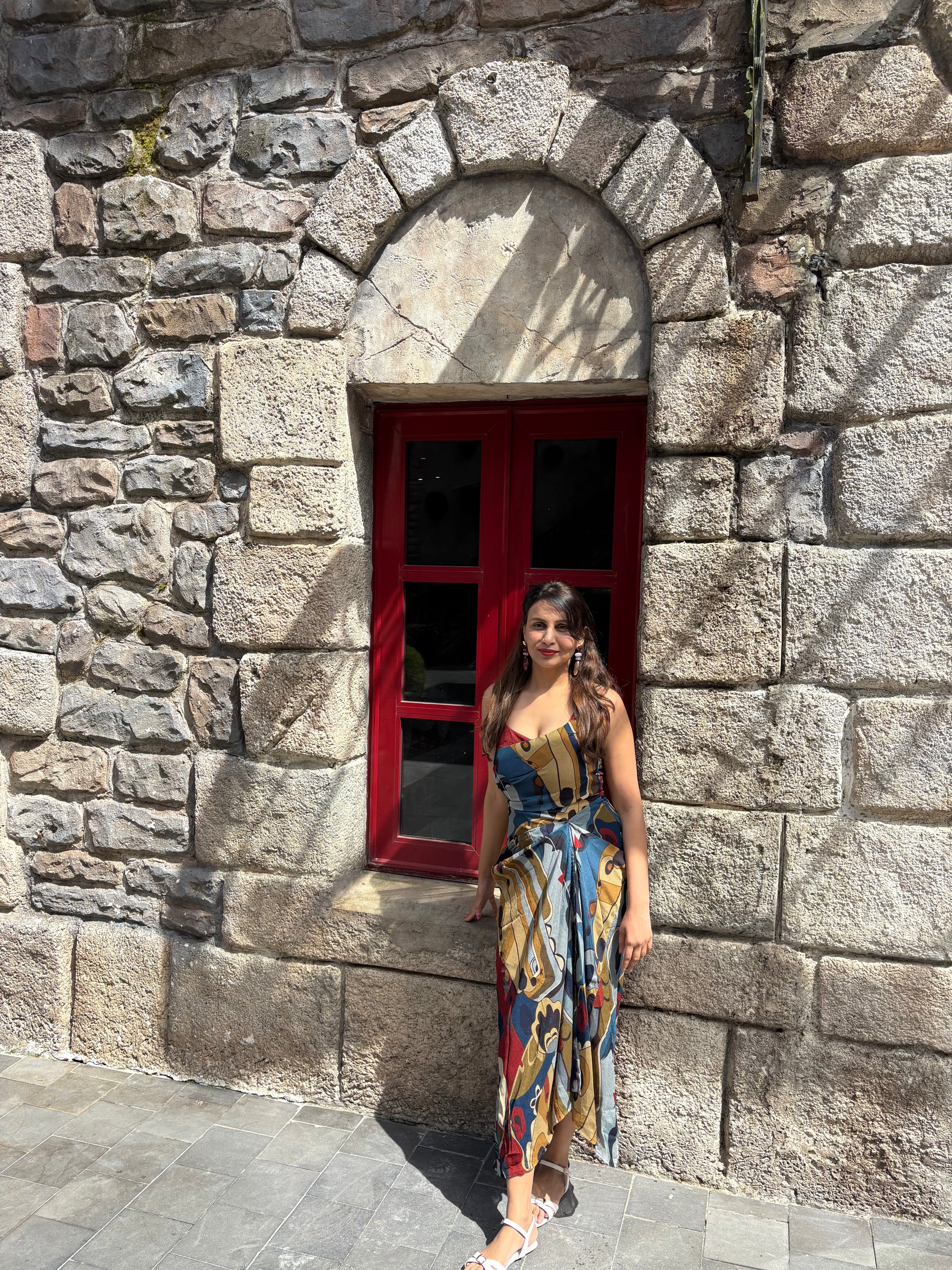 Flowy chinon midi dress with multicolor abstract print and subtle front slit, ideal for holiday and day-to-evening styling