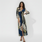 V-neck maxi dress with a central twist knot design and three-quarter length sleeves. This piece features a bold, multi-colored abstract floral-inspired print that offers a modern take on seasonal transitional wear.
