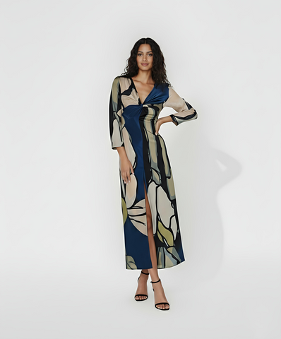 V-neck maxi dress with a central twist knot design and three-quarter length sleeves. This piece features a bold, multi-colored abstract floral-inspired print that offers a modern take on seasonal transitional wear.