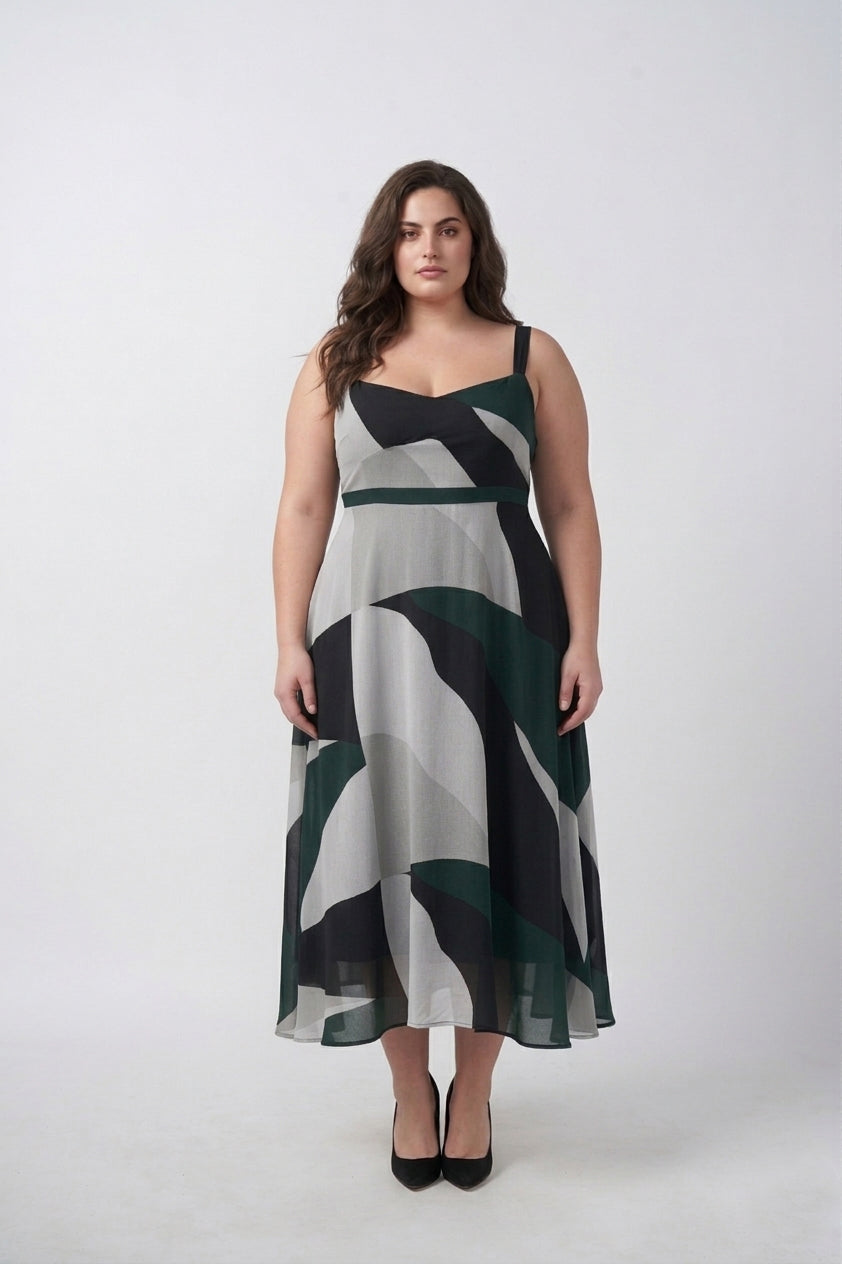 Detail of fluid crepe fabric drape on a green abstract midi dress, offering soft movement without clinging
