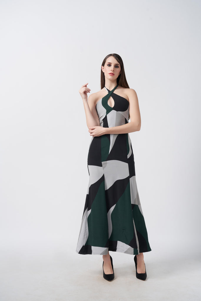 Model wearing an ankle-length halter neck crepe dress with green, black, and grey abstract print on white base.