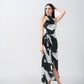 Model posing with one arm raised in a satin dress featuring dark green, black, and white abstract print with asymmetrical hemline.