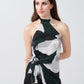 Close-up of the halter neckline and abstract pattern on the satin dress, highlighting the tie-back detail.