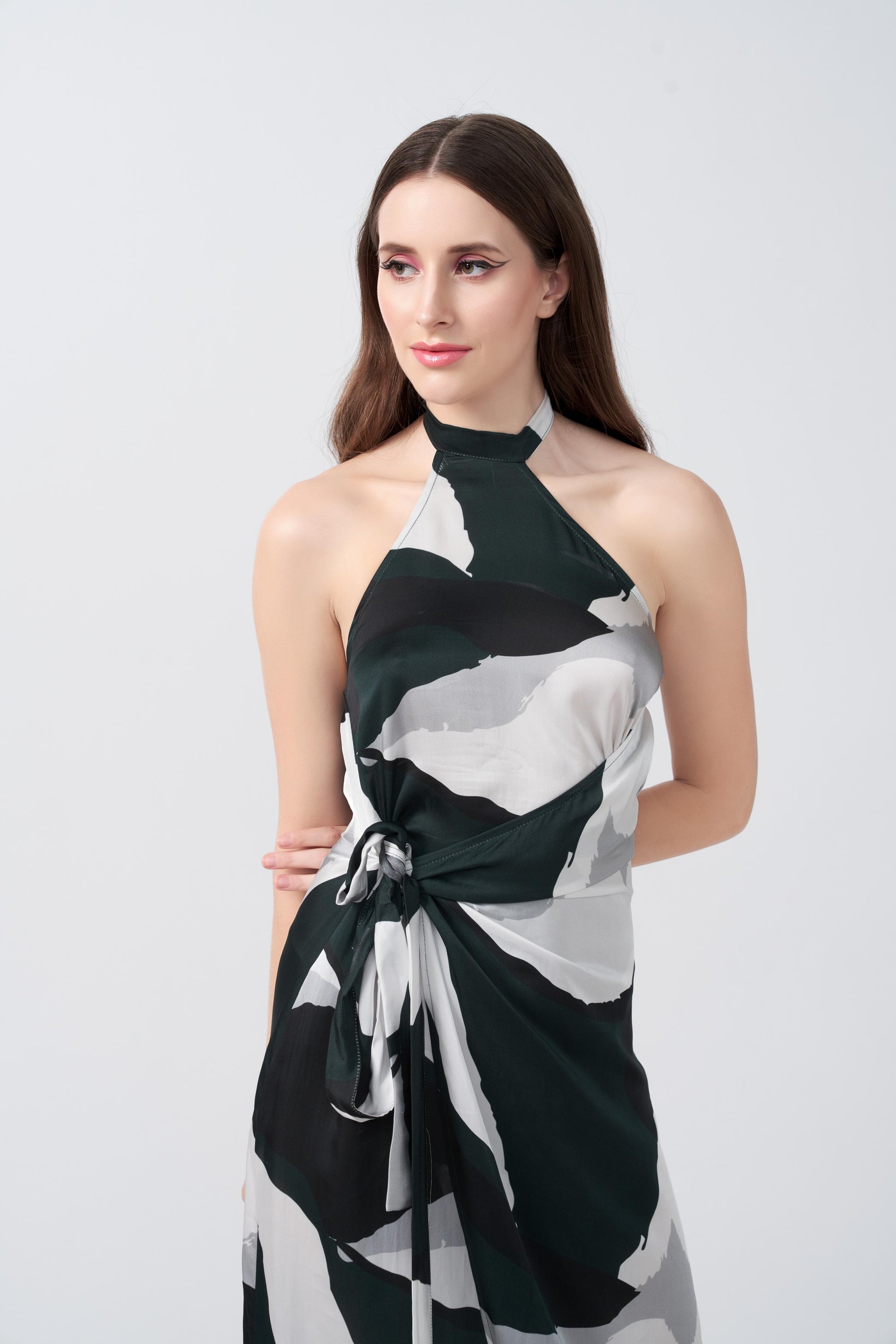 Close-up of the halter neckline and abstract pattern on the satin dress, highlighting the tie-back detail.