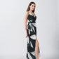Side profile of the model wearing the abstract print wrap dress with a flowy ankle-length hem.