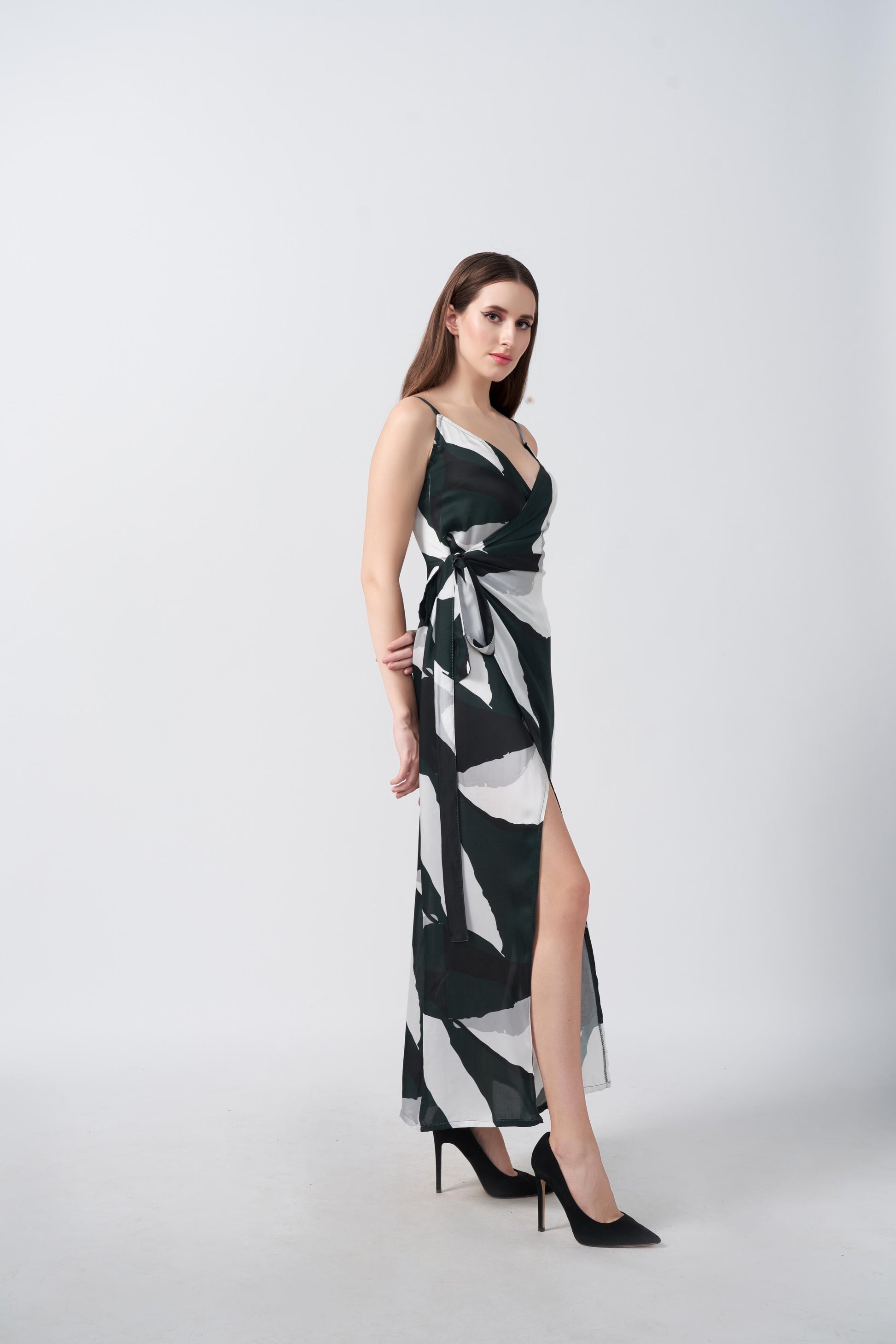 Side profile of the model wearing the abstract print wrap dress with a flowy ankle-length hem.