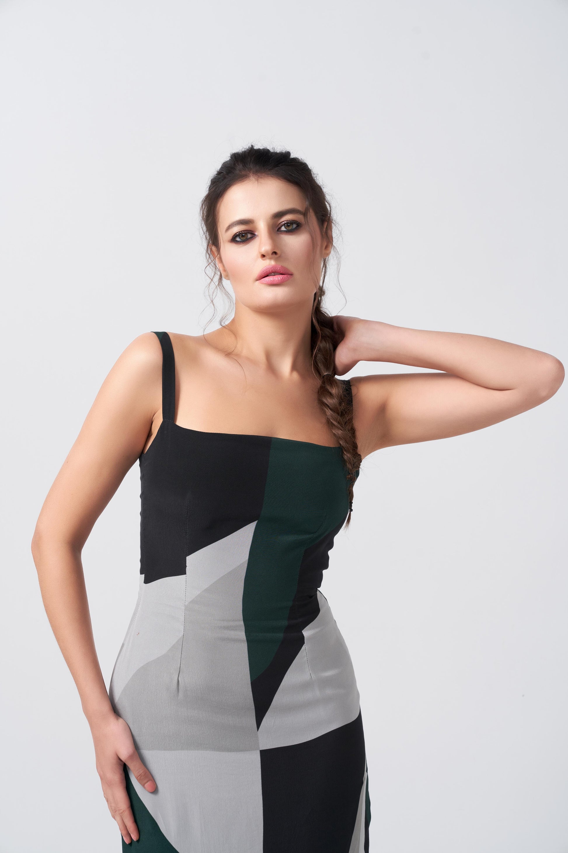 Close-up of square neckline and fitted bodice in abstract print crepe dress, capturing modern tailoring details.