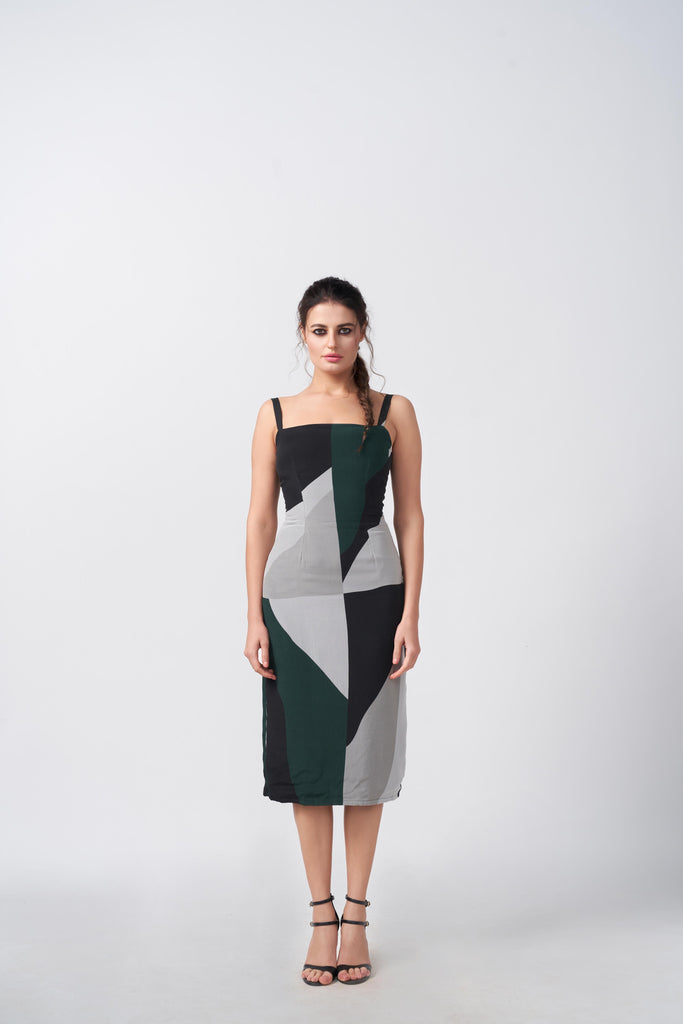 Model facing front in a green, black, and grey abstract print midi dress with square neckline, highlighting the structured silhouette.