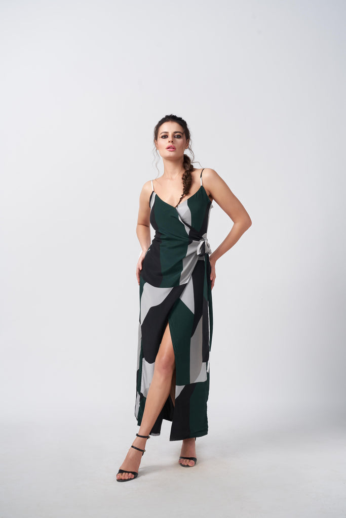Model facing front in green, black and grey abstract print crepe dress with overlap V-neck and ankle-length silhouette.
