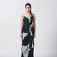 Walking view of the model in green abstract crepe wrap dress, highlighting its ankle-length flow and side slit.