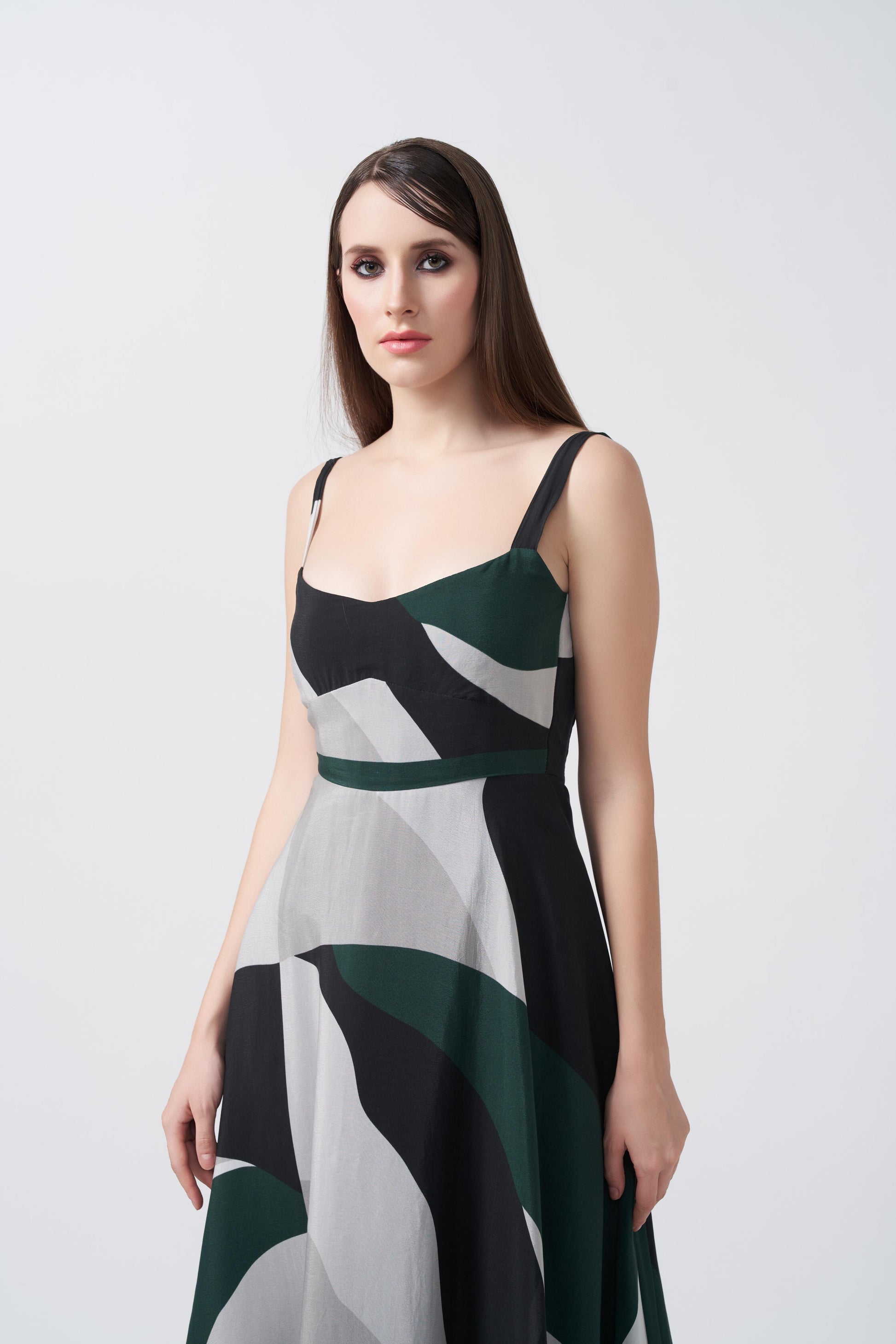 Close-up of the model in green, black, and grey midi dress highlighting neckline and print.