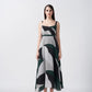 Model facing front in a green, black, and grey abstract print midi dress with delicate straps.
