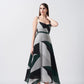 Model walking in studio in abstract print midi dress, showcasing fabric movement.