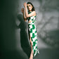 Walking pose with one leg forward, highlighting movement and the high slit of the green printed co-ord set.
