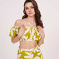 Zoomed-in front view showing the off-shoulder puff sleeves and ruched front detail of the green floral co-ord crop top.