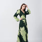 Model walking forward in the green floral ankle-length dress, highlighting the slit and graceful movement of the fabric.