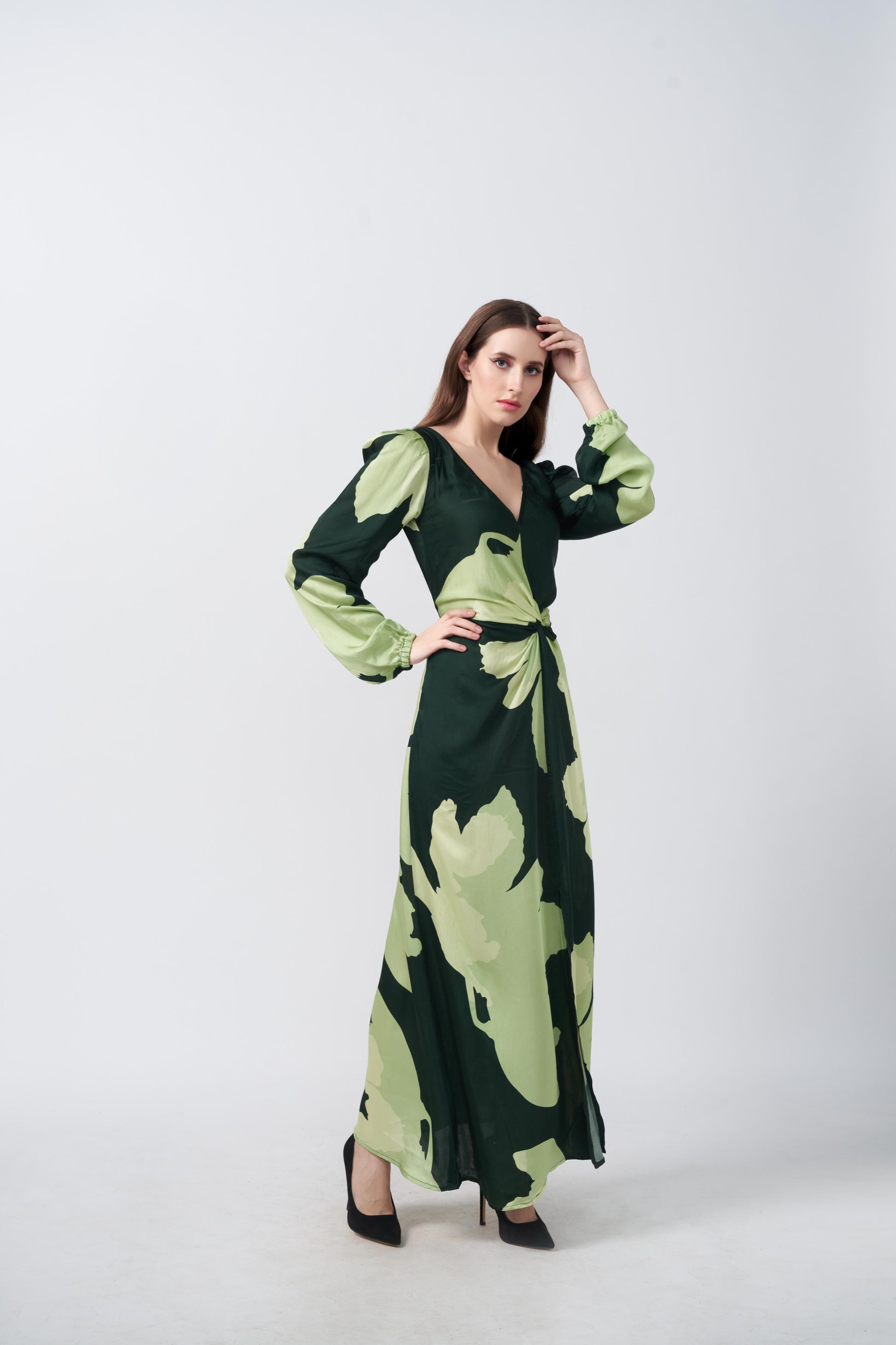 Model walking forward in the green floral ankle-length dress, highlighting the slit and graceful movement of the fabric.