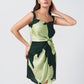 Close-up shot of the twisted front knot and shoulder straps in the satin green floral dress.