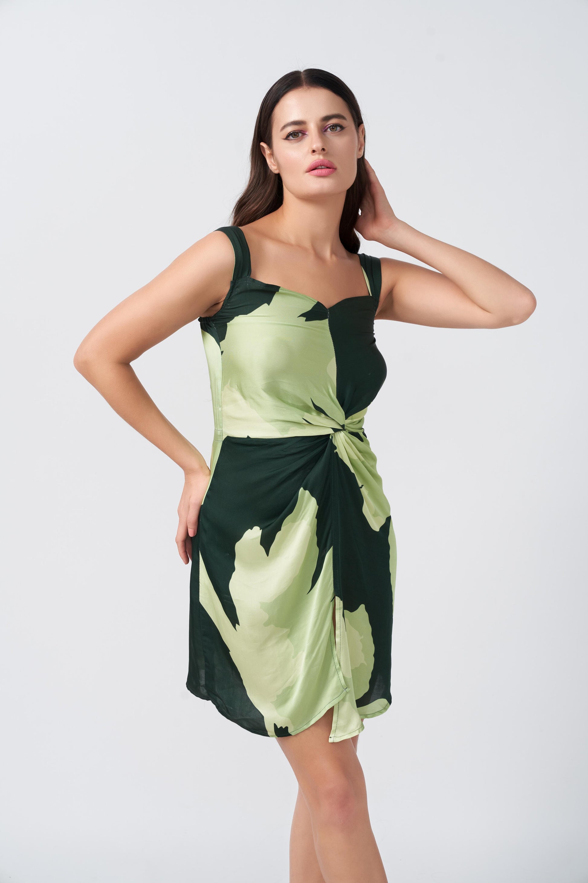 Close-up shot of the twisted front knot and shoulder straps in the satin green floral dress.