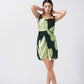 Model with arms up, highlighting the playful elegance and drape of the short green floral satin dress.