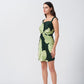 Model in profile view showcasing the elegant shoulder straps and sleek silhouette of the green floral dress.