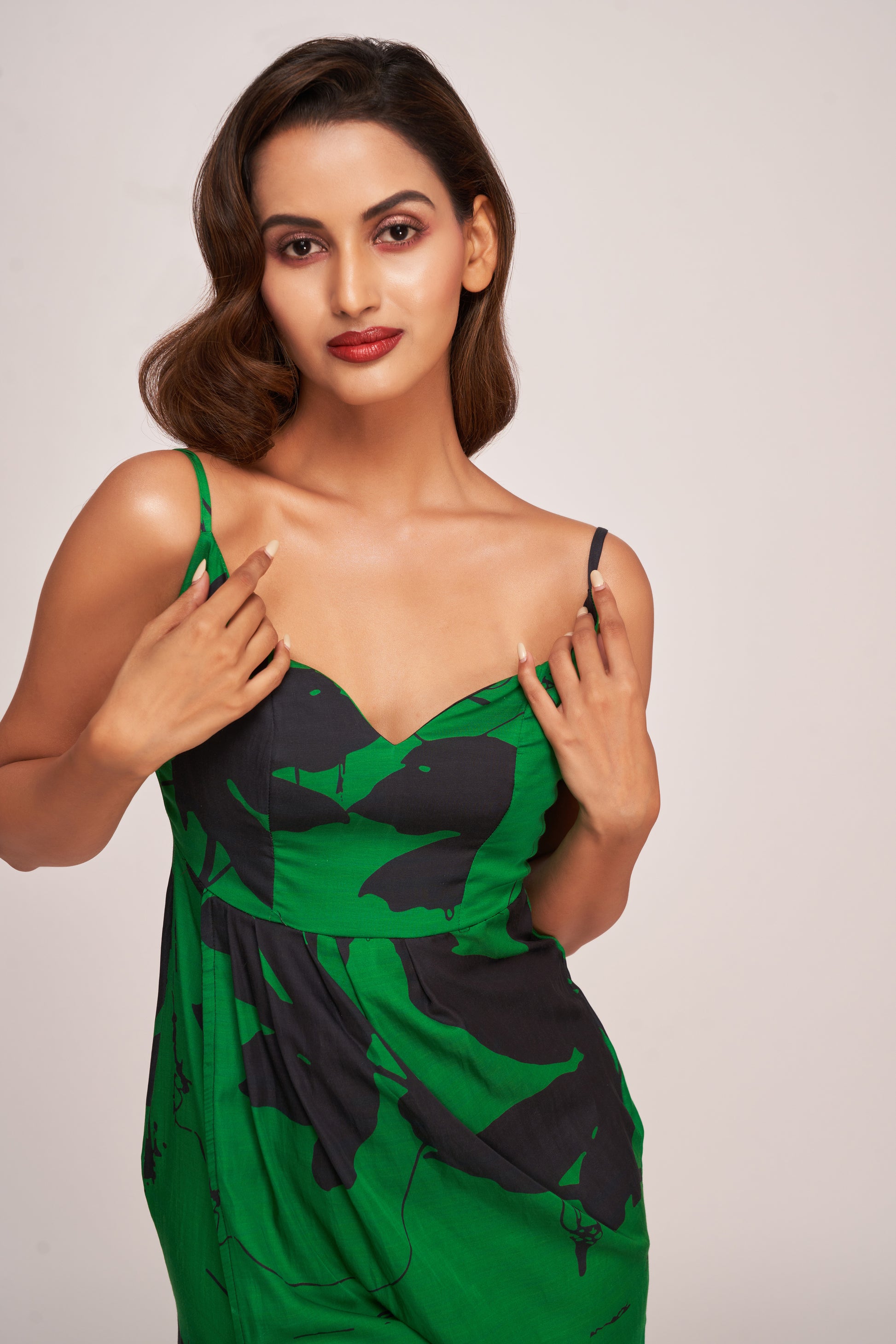 Close-up of green and black satin dress showing sweetheart neckline and delicate shoulder straps.