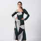 Model in front-facing pose wearing green, black, and grey abstract crepe dress with long sleeves.