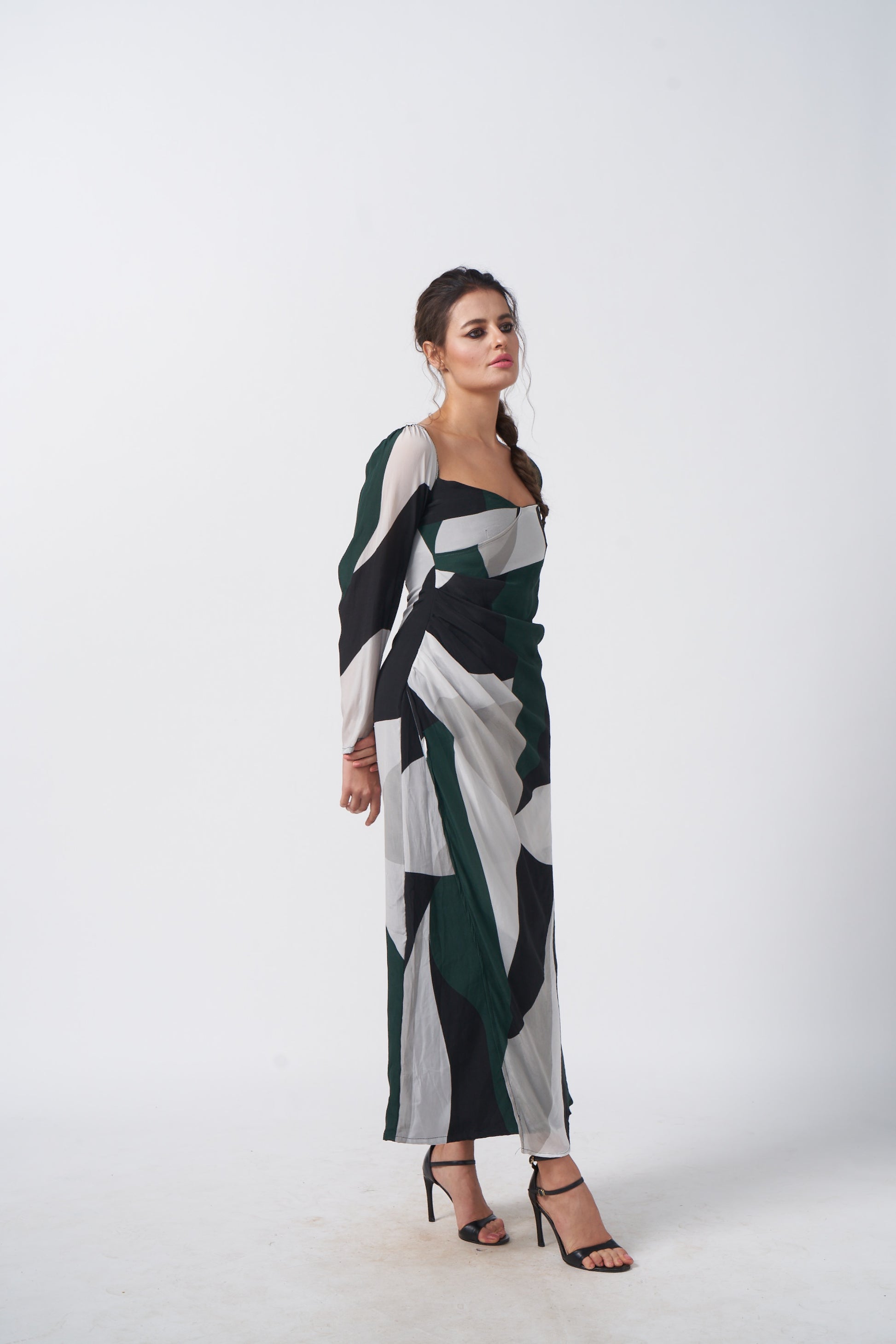Full-length view showcasing the ankle-length flare and long sleeves of the abstract printed dress.