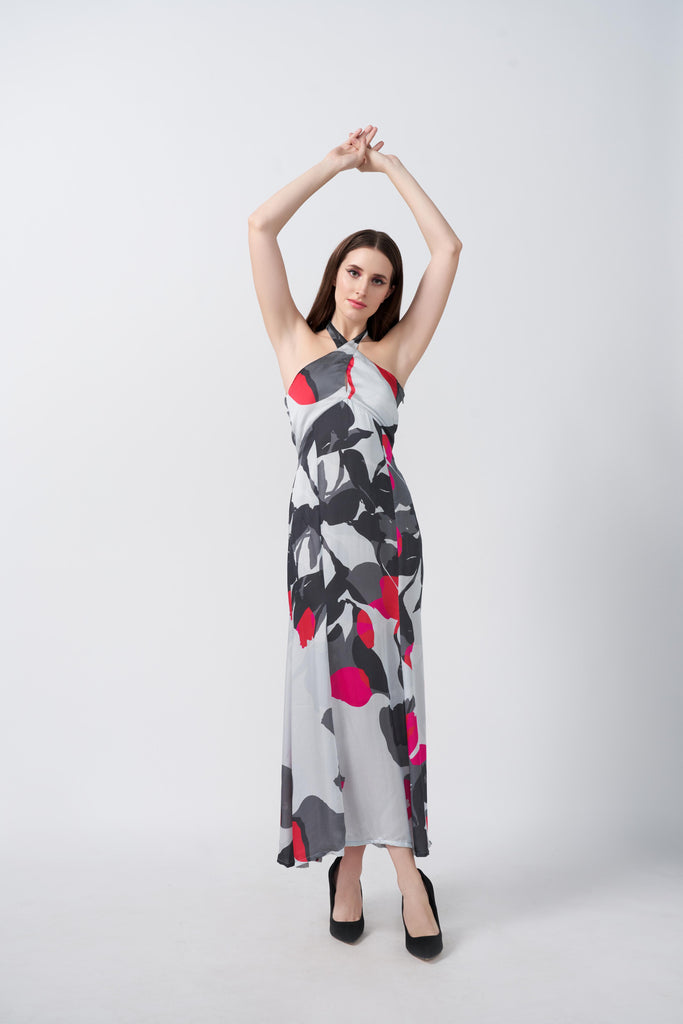 Model posing with arms raised in a grey and white abstract floral satin dress, highlighting the halter neckline and graceful silhouette.