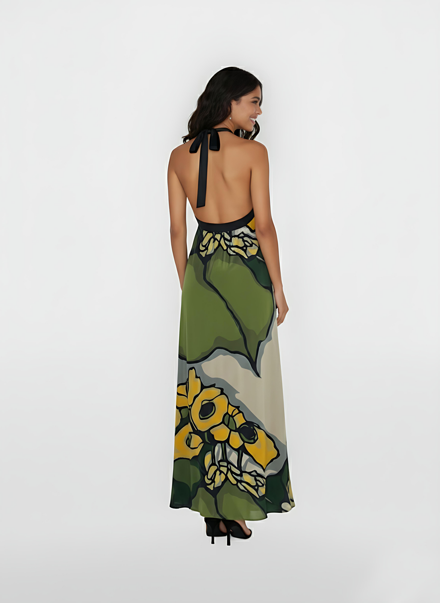 Ankle-length dress showcasing a dramatic backless design with a sleek, black halter tie-neck. The lightweight, airy fabric drapes beautifully from the shoulders, highlighting the bold contrast between the deep green leaves and the soft cream base.