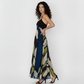Sleeveless ankle-length crepe dress with a halter tie-back neckline and a flowing silhouette, featuring a navy blue and olive abstract floral print for an elegant, contemporary look.