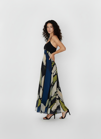 Sleeveless ankle-length crepe dress with a halter tie-back neckline and a flowing silhouette, featuring a navy blue and olive abstract floral print for an elegant, contemporary look.