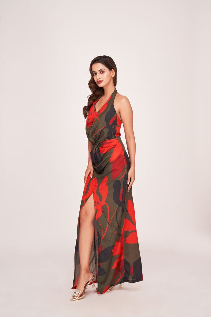 Model wearing a multicolour satin long dress with halter neck, knot detail at the waist, and thigh-high slit.
