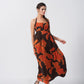 Orange and brown abstract print halter dress with a tie-back detail, ideal for evening gatherings and formal occasions
