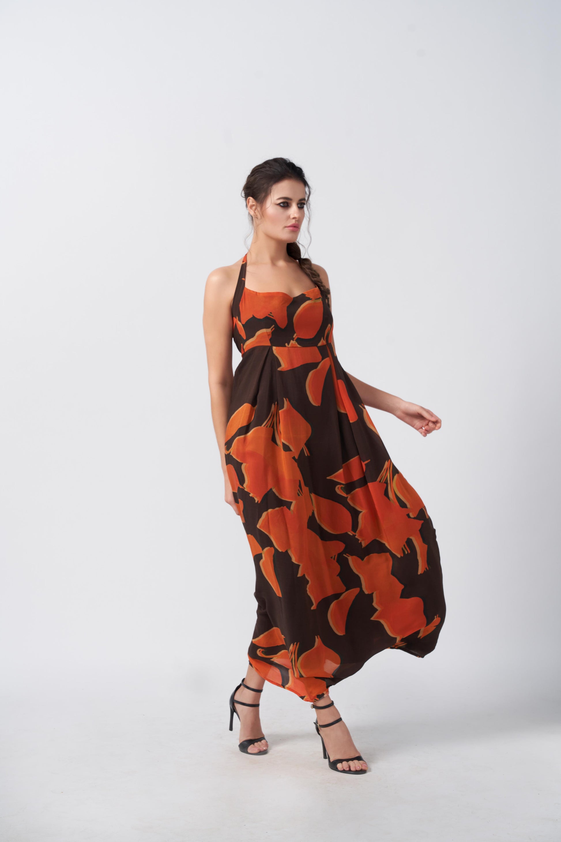 Orange and brown abstract print halter dress with a tie-back detail, ideal for evening gatherings and formal occasions