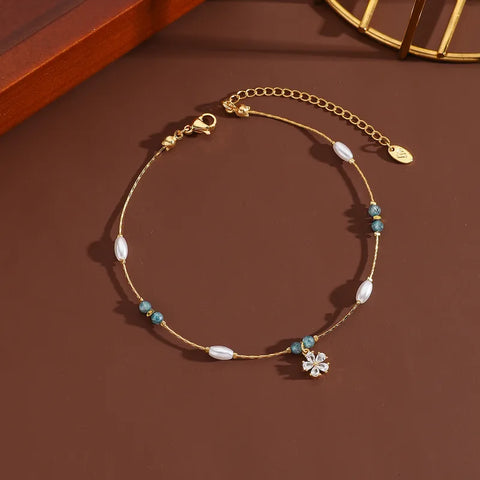 A delicate and feminine gold anklet with a sparkling flower centerpiece, designed to add a graceful touch to your summer vacation or seaside event outfits.