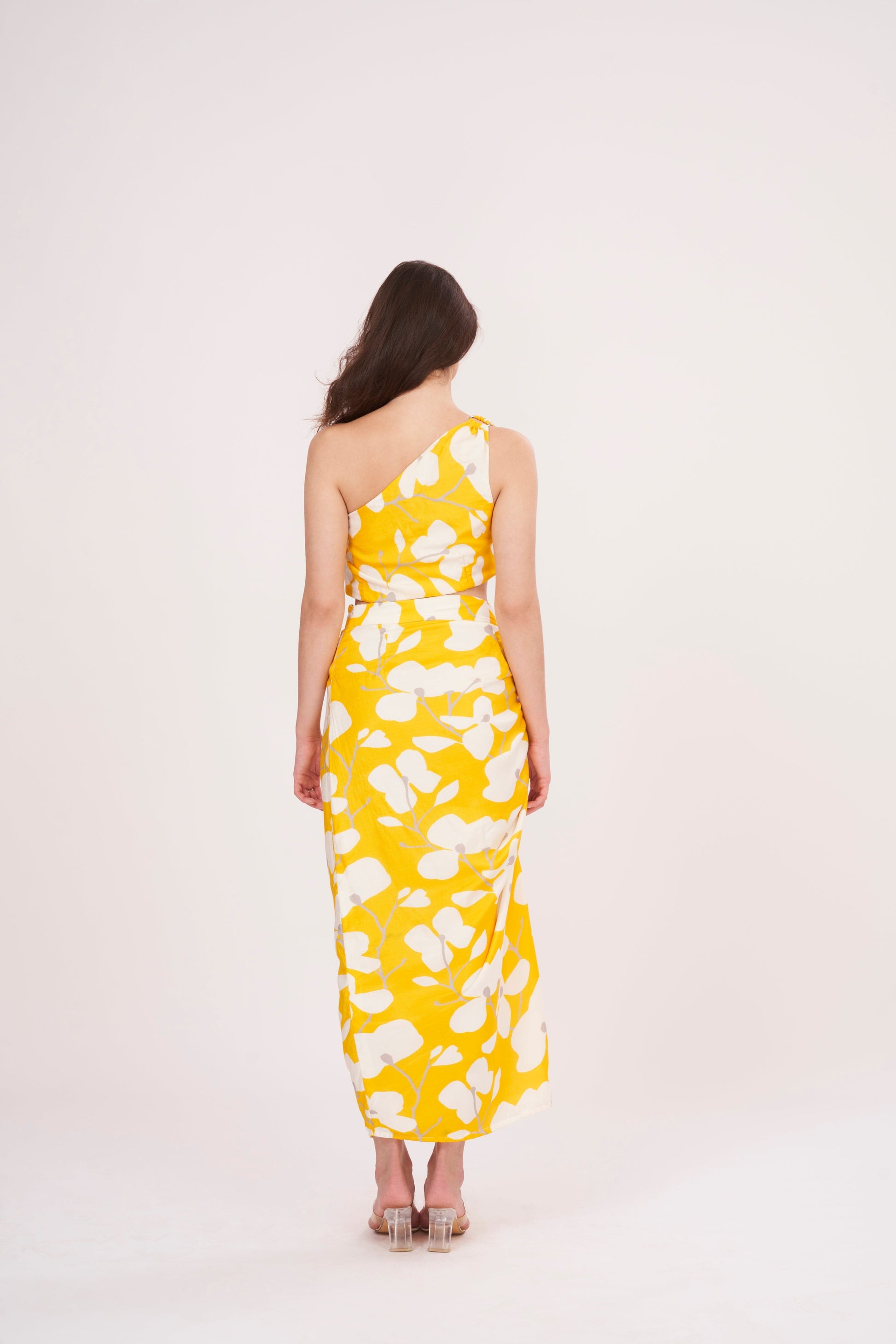 Stylish long skirt with vibrant yellow floral print, perfect for summer. Flattering waist cut creates stunning silhouette, while slit adds touch of elegance. 